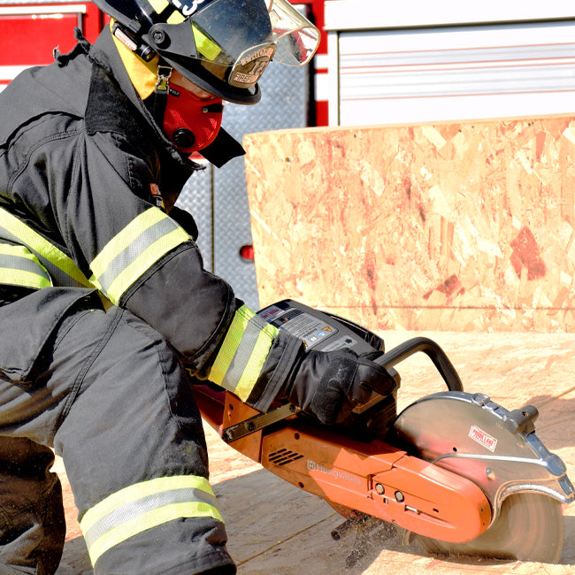 firefighter wearing rz mask m2 red while cutting plywood with a saw