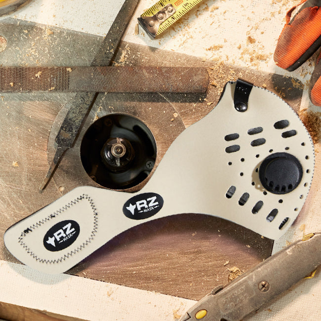 rz mask m1 neoprene natural sitting on a workbench with sawdust and tools scattered around