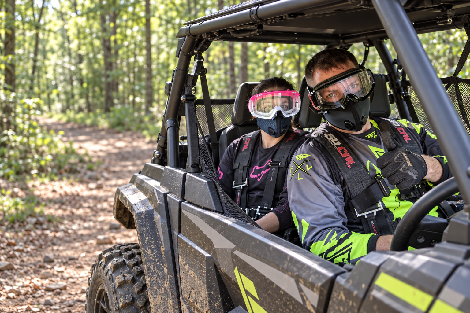 Masked riders seated in a side-by-side UTV with a visible roll cage, steering wheel and off-road tires on a wooded trail