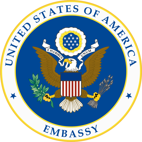 Seal of the United States with 'Embassy' text on a blue background