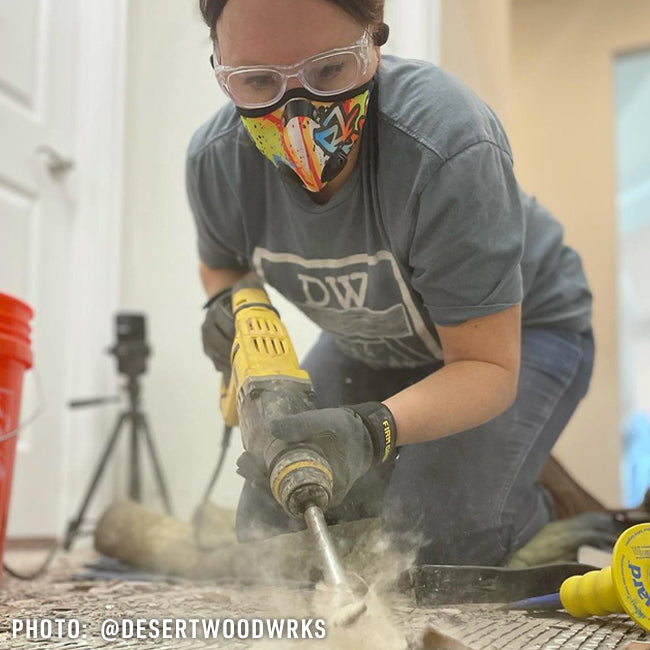 woman wearing an rz mask m2n graffiti mask while removing tile in a kitchen