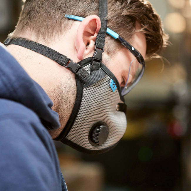 man wearing an rz mask m2.5 titanium with safety glasses while in a workshop