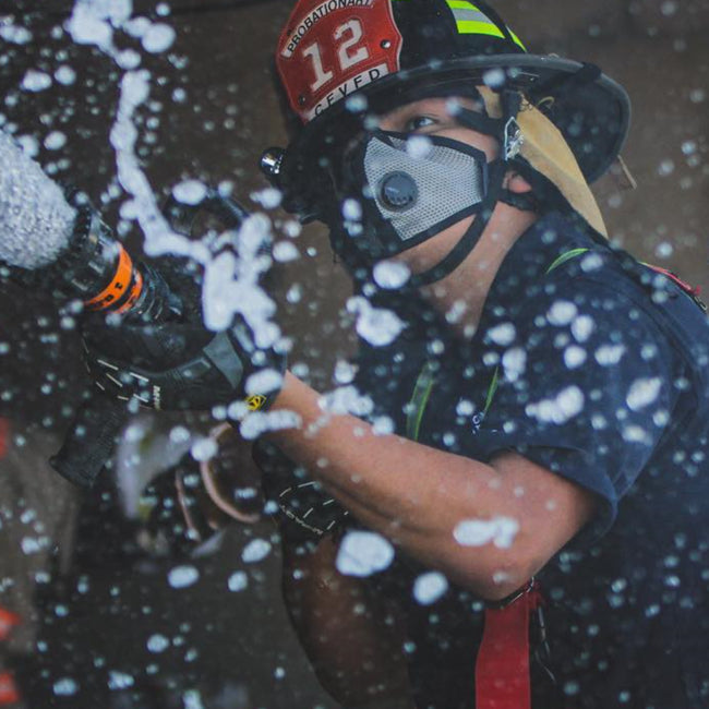 Firefighter Wearing RZ Mask M2.5 Titanium Mask while spraying fire hose