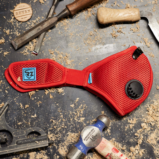 RZ Mask M2 Mesh Red Laying on a workbench table with some sawdust and various tools around it.