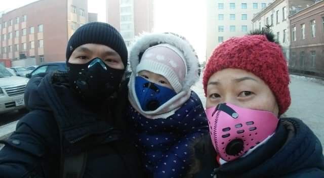Image of three people in Mongolia, one man, one woman and one child, wearing rz masks to protect against pollution.