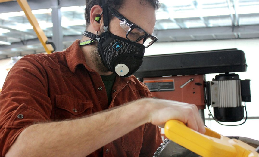 Man woodworking using table saw while wearing RZM3 Mask