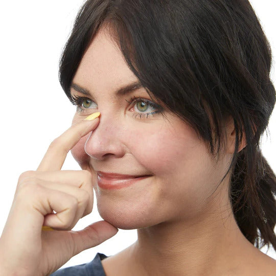 woman with two fingers to her face with placement of her thumb on her chin and her pointer finger on the bridge of her nose to demonstrate the distance to measure to determine the size of rz mask to wear.