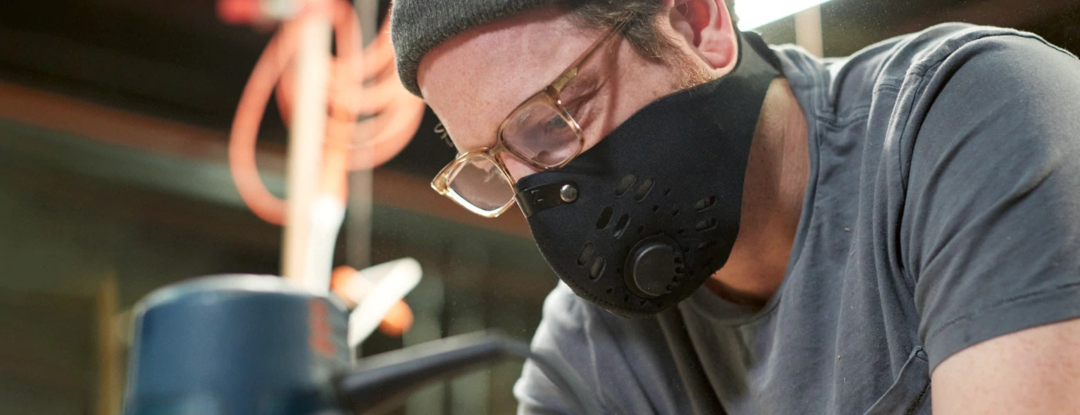 man with glasses wearing rz mask m1 black while in a woodshop