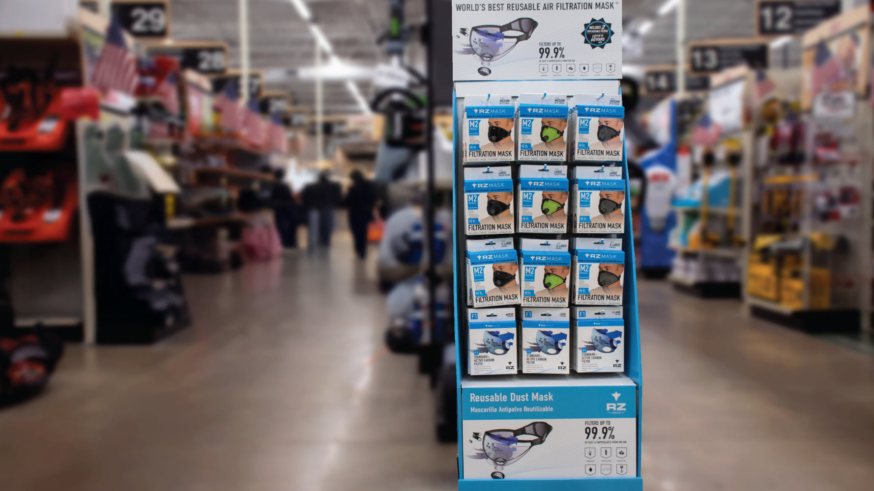 RZ Mask retail display in a hardware store aisle featuring M2 masks and filters on a blue stand.