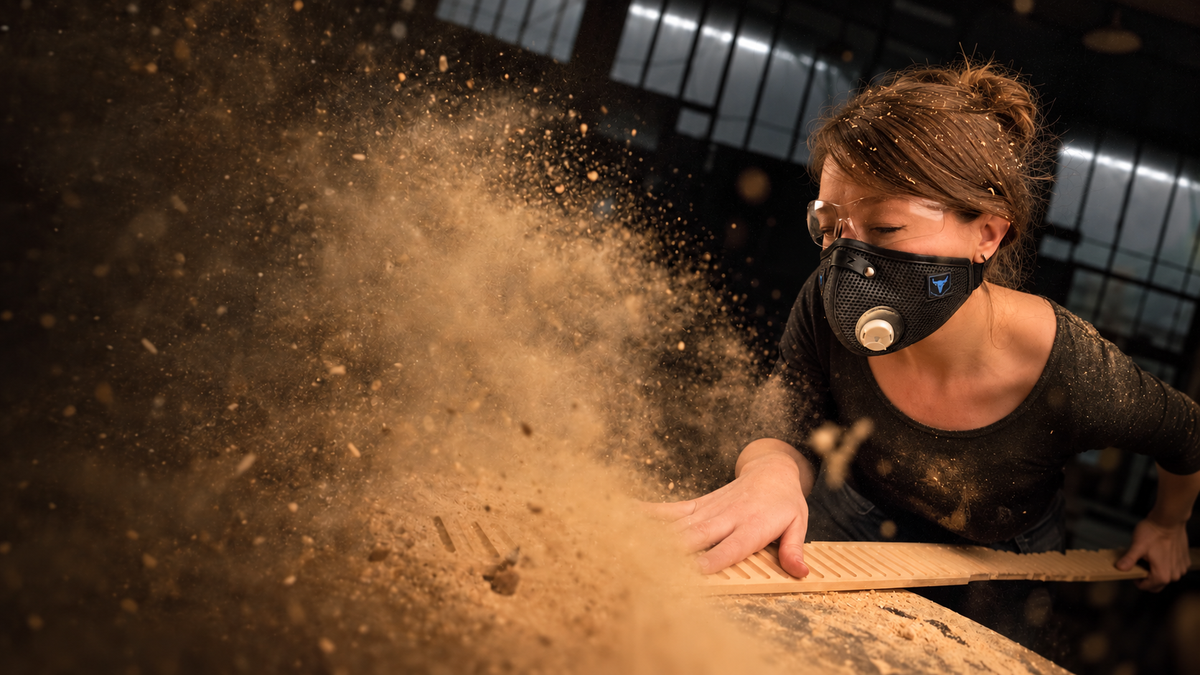 Person wearing an RZ mask while working with wood