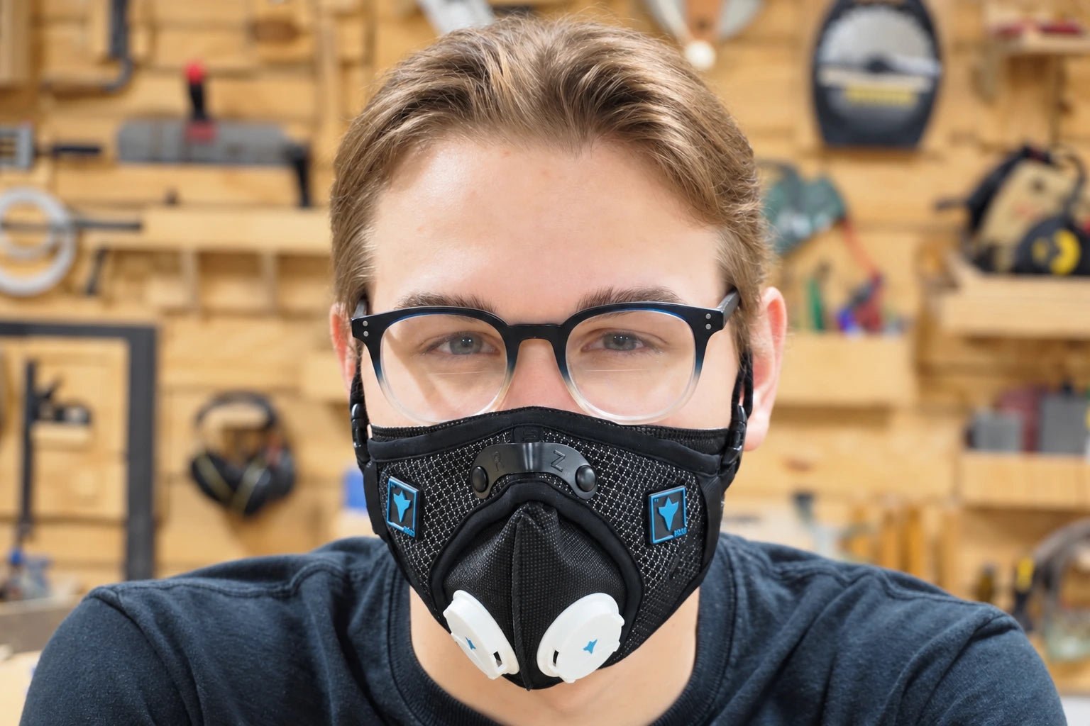 A maker wearing an RZ mask and glasses in a workshop